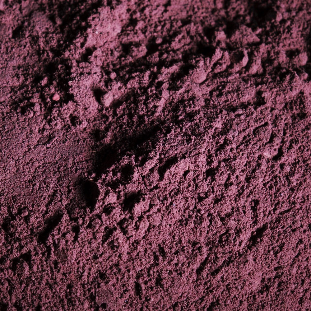 Image of the Forgotten Fruit purple herbal bath soak in powder form before adding to the bath. 